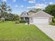 Inviting home exterior with well-manicured lawn, mature landscaping, and an attached two-car garage at 422 Cypress View Dr, Oldsmar, FL 34677