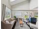 Inviting living room featuring vaulted ceilings, a comfortable sofa, and serene backyard views at 422 Cypress View Dr, Oldsmar, FL 34677
