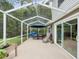 Spacious screened patio with outdoor seating, a grill, and a serene view of the surrounding greenery at 422 Cypress View Dr, Oldsmar, FL 34677