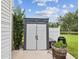 Backyard shed provides storage space, complemented by landscaping and a view of the pond at 422 Cypress View Dr, Oldsmar, FL 34677