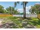 Spacious backyard showcasing healthy grass, a mix of wood and white fencing, and mature trees at 4434 Perch St, Tampa, FL 33617