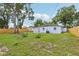 Grassy yard featuring partial fencing, mature trees, and a home with a white exterior at 4434 Perch St, Tampa, FL 33617