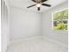 Bright bedroom featuring a ceiling fan, window with natural light, closet and smooth tile floors at 4434 Perch St, Tampa, FL 33617