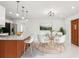 Open-concept dining area features modern lighting, round glass table, and seating for four by the kitchen at 4434 Perch St, Tampa, FL 33617