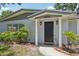 Charming home with gray and white exterior, black front door, and well-maintained landscaping at 4434 Perch St, Tampa, FL 33617