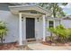 Inviting front porch with classic columns and a black front door, surrounded by lush landscaping at 4434 Perch St, Tampa, FL 33617