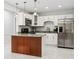 Modern kitchen featuring stainless steel refrigerator, white cabinets, granite countertops, and a kitchen island with unique wood accent at 4434 Perch St, Tampa, FL 33617