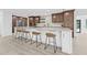 Modern eat-in kitchen boasts a large island, stainless steel appliances, stylish bar stools, and wooden cabinets at 4495 Clearwater Harbor S Dr, Largo, FL 33770