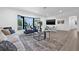 Bright living room with large window, modern furniture, light wood flooring, and a neutral color scheme at 4495 Clearwater Harbor S Dr, Largo, FL 33770