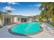 Enjoy a refreshing dip in this kidney-shaped pool surrounded by lush tropical landscaping at 4495 Clearwater Harbor S Dr, Largo, FL 33770