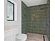 Shower with green tiling, black shower head and built-in niche at 4495 Clearwater Harbor S Dr, Largo, FL 33770