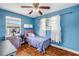 Bright bedroom features a ceiling fan, updated windows, and charming blue walls and flooring at 5001 37Th N Ave, St Petersburg, FL 33710