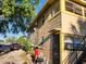 View of the side of the tan two-story home with a driveway and outdoor seating at 516 7Th W Ave # 1, Palmetto, FL 34221