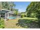 Expansive backyard featuring a screened-in pool and lush green lawn at 5423 Windbrush Dr, Tampa, FL 33625