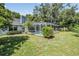 Green backyard featuring a screened-in pool and mature trees that provide ample shade at 5423 Windbrush Dr, Tampa, FL 33625