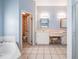 Well lit bathroom with tiled floor, bathtub, toilet, and double sink vanity at 5423 Windbrush Dr, Tampa, FL 33625