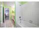 Green bathroom with walk-in shower, single sink vanity, and bathtub at 5423 Windbrush Dr, Tampa, FL 33625