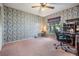 Carpeted room featuring wallpaper, a ceiling fan, a window, and a desk at 5423 Windbrush Dr, Tampa, FL 33625