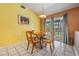 Sunlit dining area with views of the pool, tile flooring, and yellow walls at 5423 Windbrush Dr, Tampa, FL 33625