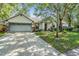 Charming home featuring a two-car garage, landscaped front yard, and beautiful curb appeal at 5423 Windbrush Dr, Tampa, FL 33625