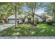 Charming single-story home with lush landscaping, mature trees, and a well-manicured lawn at 5423 Windbrush Dr, Tampa, FL 33625