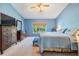 Bright main bedroom with blue walls, a large window overlooking backyard greenery, and neutral carpet at 5423 Windbrush Dr, Tampa, FL 33625