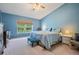 Comfortable main bedroom featuring blue walls, a window with natural light, and a ceiling fan at 5423 Windbrush Dr, Tampa, FL 33625
