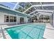 Screened-in pool features a sparkling blue swimming pool, patio area, and ample sunshine at 5423 Windbrush Dr, Tampa, FL 33625