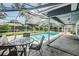 Pool area with screen enclosure, outdoor table and chairs, and enclosed yard at 5423 Windbrush Dr, Tampa, FL 33625
