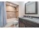 Bathroom with tiled shower and vanity with dark countertop at 6 Harbor Cove St, Safety Harbor, FL 34695