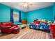 A bedroom with blue walls, hardwood flooring, a ceiling fan, and window at 6 Harbor Cove St, Safety Harbor, FL 34695