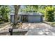 View of the home's front exterior featuring a brick driveway, and a lush tree-lined yard at 6 Harbor Cove St, Safety Harbor, FL 34695
