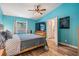 Bedroom with teal walls, wood floors, a ceiling fan, and a large window at 6 Harbor Cove St, Safety Harbor, FL 34695