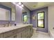 Bathroom featuring double sinks, grey cabinets, marble countertops, and a large window at 604 Knollwood Dr, Largo, FL 33770