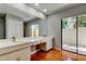 Bright bathroom with a double vanity, a large mirror, and a glass door that opens to the outside at 604 Knollwood Dr, Largo, FL 33770