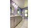 Bathroom featuring double sinks, grey cabinets, marble countertops, and a large window at 604 Knollwood Dr, Largo, FL 33770