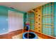 Bright bedroom featuring wood floors, a climbing structure, storage closet, and a mini trampoline at 604 Knollwood Dr, Largo, FL 33770