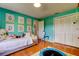 Bright bedroom featuring wood floors, a trundle bed, wall art, and a mini trampoline at 604 Knollwood Dr, Largo, FL 33770