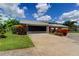 Charming house featuring well-maintained lawn and a two-car garage with dark door at 604 Knollwood Dr, Largo, FL 33770