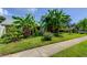 Lush front yard with tropical plants and mature trees offering a private and welcoming entrance at 604 Knollwood Dr, Largo, FL 33770
