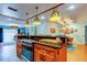 Open concept kitchen features dark countertops, stainless steel oven, custom wood cabinets, and seamless flow to dining and living rooms at 604 Knollwood Dr, Largo, FL 33770