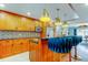 Bright kitchen with stainless steel appliances, custom wood cabinets, an island with bar seating, and views to dining and living rooms at 604 Knollwood Dr, Largo, FL 33770