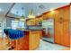 Well-lit kitchen features stainless steel refrigerator, custom wood cabinets, an island with bar seating, and unique backsplash at 604 Knollwood Dr, Largo, FL 33770