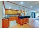 Open kitchen featuring an island with seating, wood cabinetry, and pendant lighting at 604 Knollwood Dr, Largo, FL 33770