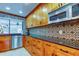 Bright kitchen boasts stainless steel appliances, custom wood cabinets, decorative backsplash, and black countertops at 604 Knollwood Dr, Largo, FL 33770
