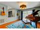 Stunning music room with blue parrot rug, piano and hard wood flooring throughout at 604 Knollwood Dr, Largo, FL 33770