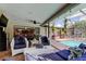 Charming outdoor seating area with a view of the pool and living room, perfect for relaxing and entertaining at 604 Knollwood Dr, Largo, FL 33770