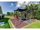 Backyard playground with a protective canopy, perfect for active  at 604 Knollwood Dr, Largo, FL 33770