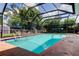 Screened in-ground swimming pool, ladder, diving board, and outdoor seating at 604 Knollwood Dr, Largo, FL 33770