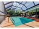 Screened in-ground swimming pool, ladder, diving board, and outdoor seating at 604 Knollwood Dr, Largo, FL 33770